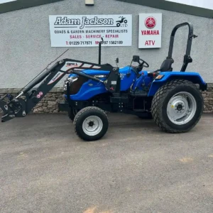 Blue Solis compact tractor with front loader outside the showroom